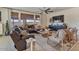 Inviting living room with a comfortable leather sofa, wood-look tile flooring, and natural light from large windows at 25800 N 140Th Ln, Surprise, AZ 85387