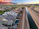 Aerial view of neighborhood with a canal, homes with swimming pools, landscaping, and mountain views in the distance at 2617 S Jeffry St, Gilbert, AZ 85295