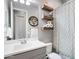 Bright bathroom featuring a vanity with gray cabinets, modern lighting, floating shelves, and decorative wall art at 2617 S Jeffry St, Gilbert, AZ 85295