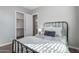 Charming bedroom features a black metal bedframe and a view into the walk-in closet and bathroom at 2617 S Jeffry St, Gilbert, AZ 85295