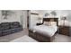 Comfortable bedroom with a gray leather sofa, a cozy bed with decorative pillows, and soft, neutral-toned decor at 2617 S Jeffry St, Gilbert, AZ 85295