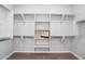 Bright, well-organized walk-in closet features ample shelving and hanging space with white cabinets and neutral carpeting at 2617 S Jeffry St, Gilbert, AZ 85295