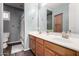 Bathroom featuring double sinks, brown cabinets, and a shower/tub combo at 30246 N 123Rd Ln, Peoria, AZ 85383