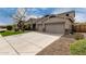 Charming home with a three-car garage and a concrete driveway surrounded by rocks and a tree at 30246 N 123Rd Ln, Peoria, AZ 85383