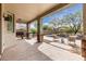 Covered patio with stone columns, built-in grill, and view of pool and outdoor seating at 30246 N 123Rd Ln, Peoria, AZ 85383