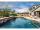 Sparkling pool with waterfall feature surrounded by lush landscaping and a spacious backyard at 30246 N 123Rd Ln, Peoria, AZ 85383