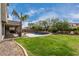 Private backyard oasis featuring a sparkling pool, lush greenery, and inviting patio area at 30246 N 123Rd Ln, Peoria, AZ 85383