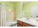 Well-lit bathroom with a shower and tub combination, bright green walls, and modern fixtures at 3206 W Sentinel Rock Rd, Phoenix, AZ 85086