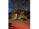 Night view of home with three car garage, desert landscaping, and elegant stone accents at 3206 W Sentinel Rock Rd, Phoenix, AZ 85086