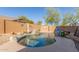 Beautiful kidney-shaped backyard pool features a rock waterfall, mature desert landscaping, and decorative wall hangings at 3206 W Sentinel Rock Rd, Phoenix, AZ 85086