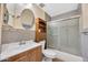 Bathroom with updated tiling and a shower with a glass door at 3220 W Laurie Ln, Phoenix, AZ 85051