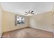 Bedroom with neutral walls, tile floors, large window and ceiling fan at 3220 W Laurie Ln, Phoenix, AZ 85051
