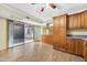 Open kitchen with wood cabinets, tile flooring, and access to outdoor space through sliding glass doors at 3220 W Laurie Ln, Phoenix, AZ 85051