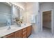 Bright bathroom featuring a double sink vanity, large mirror, and access to the walk-in closet at 3310 E Fremont Rd, Phoenix, AZ 85042