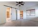 Spacious bedroom with neutral carpet, an updated ceiling fan, and ensuite bath access through a sliding barn door at 3310 E Fremont Rd, Phoenix, AZ 85042