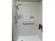 Shower with white tile, handrails, and a wood shower seat at 3310 E Fremont Rd, Phoenix, AZ 85042