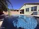 A refreshing backyard pool has a waterfall and is situated near the back of the house at 3717 E Lodgepole Dr, Gilbert, AZ 85298