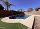 A backyard pool is surrounded by artificial turf and decorative rock creating a relaxing outdoor oasis at 3717 E Lodgepole Dr, Gilbert, AZ 85298