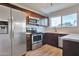 Modern kitchen with stainless steel appliances, dark wood cabinets, and white countertops at 3718 W Columbine Dr, Phoenix, AZ 85029
