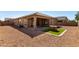 A wide view of the backyard with a covered patio and decorative rock at 41290 W Ganley Way, Maricopa, AZ 85138