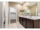 Bathroom featuring a dual sink vanity, and a walk-in closet for ample storage at 41290 W Ganley Way, Maricopa, AZ 85138