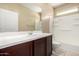 Bathroom features a large mirror, vanity with dark cabinets, and a shower-tub combo at 41290 W Ganley Way, Maricopa, AZ 85138