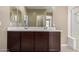 Bright bathroom with a large mirror, double sinks, and modern fixtures at 41290 W Ganley Way, Maricopa, AZ 85138