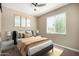 Comfortable bedroom boasts a plush bed, soft lighting, and a ceiling fan for a relaxing atmosphere at 41290 W Ganley Way, Maricopa, AZ 85138