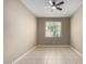 A bright bedroom with tile floors and a ceiling fan provides a cool relaxing space at 41290 W Ganley Way, Maricopa, AZ 85138