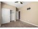 A neutral-toned bedroom has a ceiling fan, closet with sliding doors, and a TV mount at 41290 W Ganley Way, Maricopa, AZ 85138