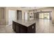 Spacious kitchen with an island, dark wood cabinetry, and an open layout leading to the living area at 41290 W Ganley Way, Maricopa, AZ 85138