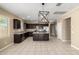 Spacious kitchen featuring dark cabinets, granite countertops, and an island with modern lighting at 41290 W Ganley Way, Maricopa, AZ 85138
