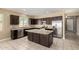Well-equipped kitchen with an island, stainless steel appliances, dark cabinetry, and granite countertops at 41290 W Ganley Way, Maricopa, AZ 85138