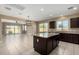 Open-concept kitchen features a large island, dark wood cabinets, and bright natural light at 41290 W Ganley Way, Maricopa, AZ 85138