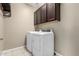 Laundry room with overhead cabinets, washer, dryer and tile floors for easy cleaning at 41290 W Ganley Way, Maricopa, AZ 85138