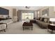 Cozy living room with comfortable seating, modern decor, and a sliding glass door to the backyard at 41290 W Ganley Way, Maricopa, AZ 85138