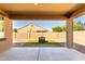 Covered patio with concrete flooring, a square grass area and rock surround at 41290 W Ganley Way, Maricopa, AZ 85138