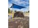 Community playground with a climbing wall, shade structure, and swings, providing fun activities for residents at 41290 W Ganley Way, Maricopa, AZ 85138