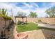 Private backyard with artificial turf, fire pit, covered dining, and pool at 42410 N 46Th Ln, Phoenix, AZ 85086