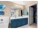 Bright bathroom with double vanity, blue cabinets, and walk-in closet for ample storage at 42410 N 46Th Ln, Phoenix, AZ 85086