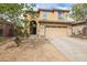 Two-story home boasts a three-car garage, desert landscaping, and covered porch at 42410 N 46Th Ln, Phoenix, AZ 85086
