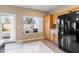 Spacious kitchen boasts tiled floor, black appliances and door leading to a beautiful backyard pool and patio at 42410 N 46Th Ln, Phoenix, AZ 85086