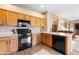 Bright kitchen featuring black appliances, neutral countertops, wood cabinets, and an eat-in dining area at 42410 N 46Th Ln, Phoenix, AZ 85086