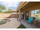 Covered patio with blue chairs overlooks a sparkling pool and landscaped backyard at 42410 N 46Th Ln, Phoenix, AZ 85086