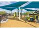 Vibrant community playground featuring a slide and climbing structure, under colorful sun-shading canopies at 42410 N 46Th Ln, Phoenix, AZ 85086