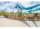 Playground with a slide, climbing structure, and protective fencing, partially covered with sun-shading canopies at 42410 N 46Th Ln, Phoenix, AZ 85086