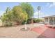 A landscaped backyard features a covered patio, a patio area, and lots of shade at 5038 E Morning Star Dr, Phoenix, AZ 85044