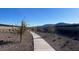 Paved walking path winding through a landscaped community space with desert foliage and mountain views at 5818 W Sunrise Dr, Laveen, AZ 85339