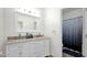 Bright bathroom featuring dual sinks, a large mirror, a shower with glass door, and a separate toilet area at 6818 W St Catherine Ave, Laveen, AZ 85339