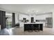 Bright kitchen with white cabinetry, stainless steel appliances, a spacious island, and sliding glass doors at 6818 W St Catherine Ave, Laveen, AZ 85339